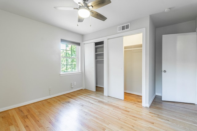 10816 Palace Way, Dallas, TX 75218 - unfurnished bedroom with multiple closets, light wood-type flooring, baseboards, and ceiling fan