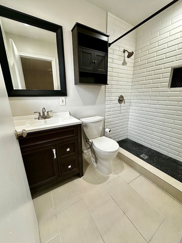 10816 Palace Way, Dallas, TX 75218 - bathroom featuring a tile shower, toilet, vanity, and tile patterned floors