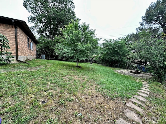 view of yard featuring central AC unit and a fire pit