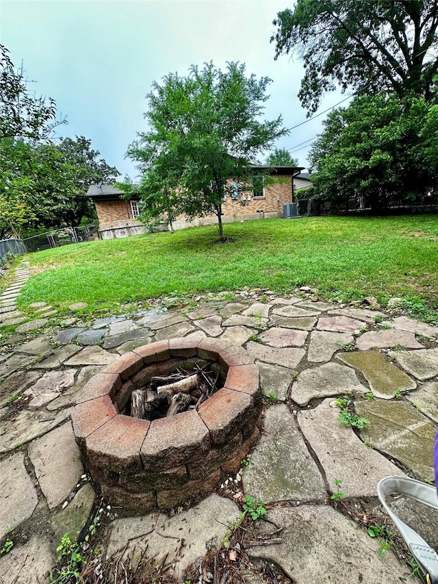 view of yard with central AC unit and an outdoor fire pit