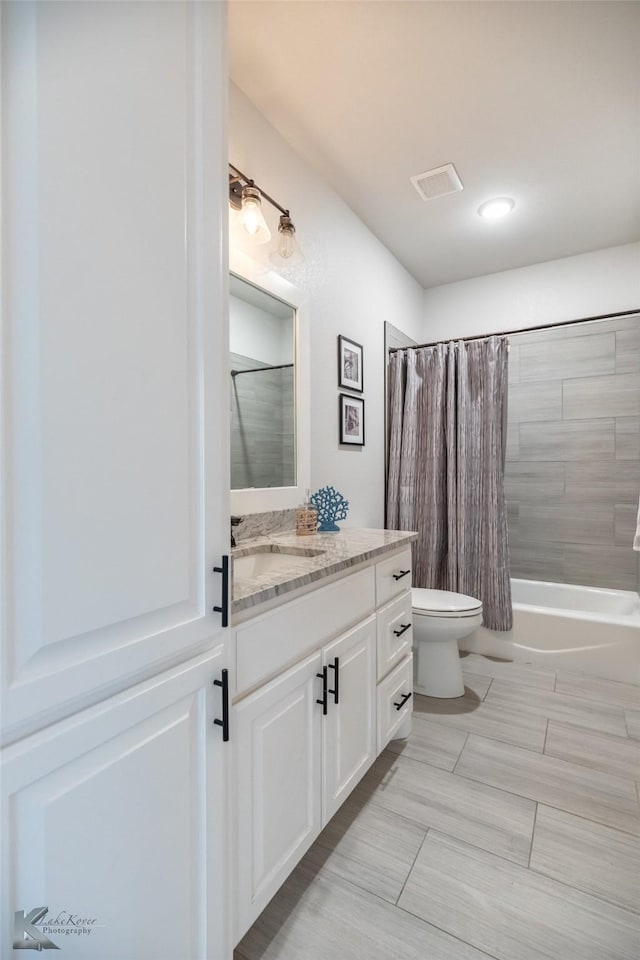 full bath with vanity, shower / tub combo with curtain, and toilet