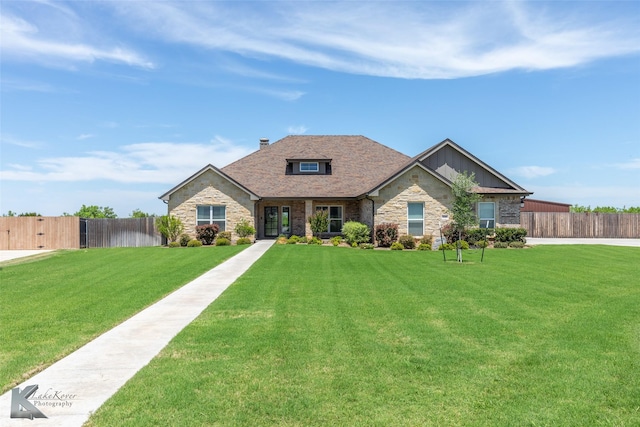 view of front of home with board and batten siding, a front yard, fence, and stone siding