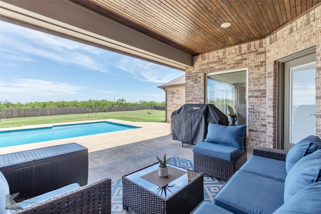 view of pool with area for grilling, outdoor lounge area, a fenced backyard, a patio area, and a lawn