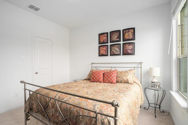 bedroom featuring baseboards, visible vents, multiple windows, and carpet