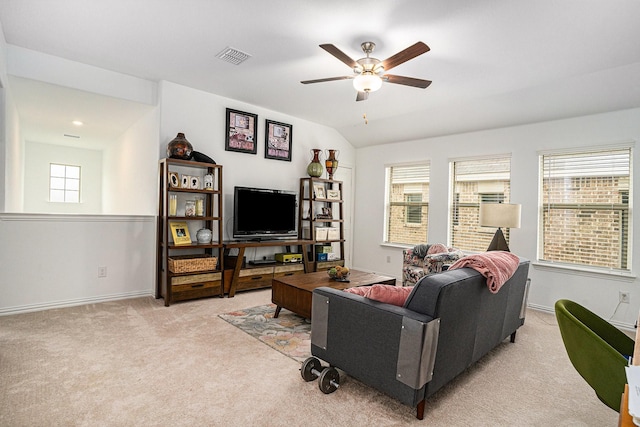 living room with carpet floors, a ceiling fan, visible vents, and plenty of natural light
