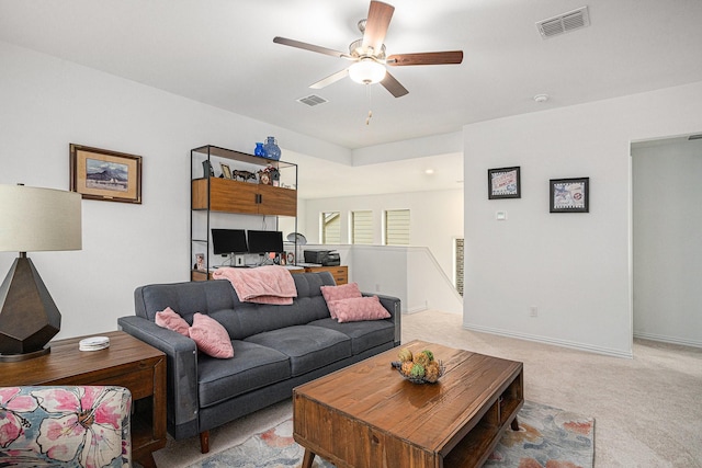 living area featuring ceiling fan, visible vents, light carpet, and baseboards
