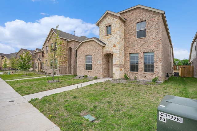 view of front of home with brick siding, fence, and a front yard