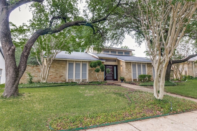 view of front of home with brick siding and a front lawn