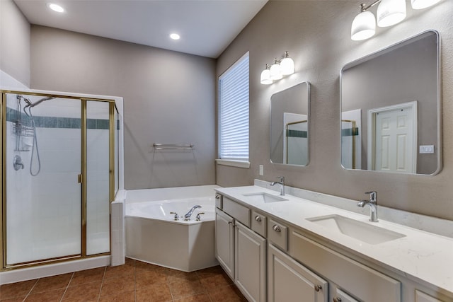 bathroom featuring a sink, double vanity, a stall shower, and a garden tub