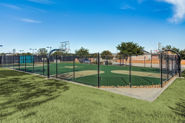view of basketball court featuring a yard, community basketball court, and fence