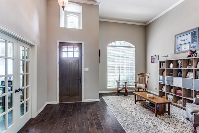 foyer entrance with crown molding, baseboards, a high ceiling, and hardwood / wood-style floors