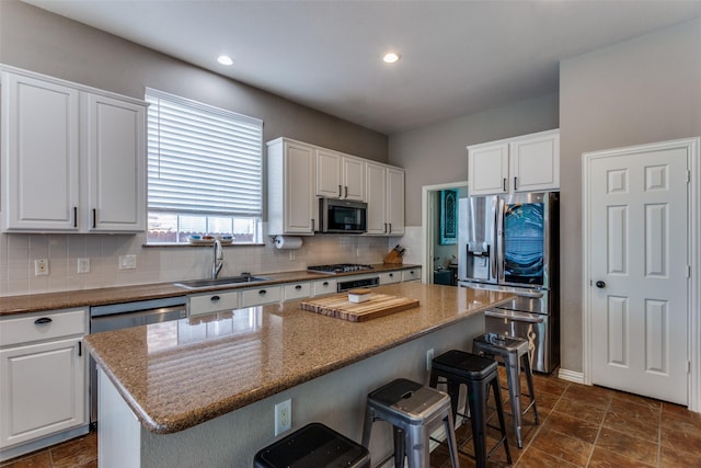 kitchen featuring stainless steel appliances, white cabinetry, and a sink