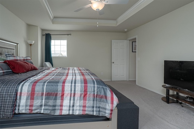 bedroom with a ceiling fan, crown molding, a raised ceiling, baseboards, and carpet flooring