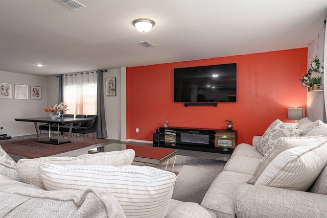 living room with baseboards, carpet flooring, and visible vents