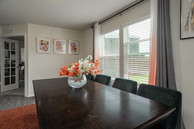 dining space with baseboards, visible vents, and wood finished floors