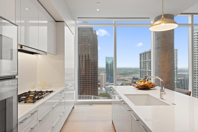 kitchen with a sink, a view of city, floor to ceiling windows, and appliances with stainless steel finishes