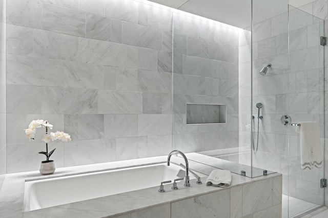 bathroom featuring a shower stall and a garden tub