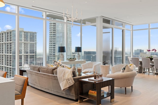interior space with a chandelier, a wealth of natural light, wood finished floors, floor to ceiling windows, and a city view