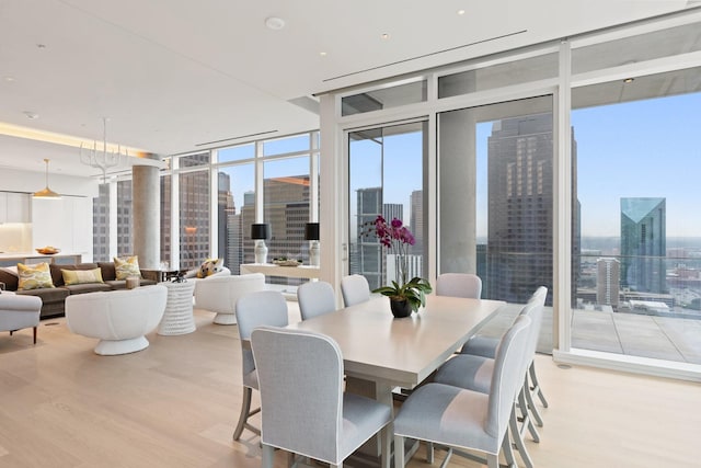 dining space featuring a view of city, floor to ceiling windows, and wood finished floors