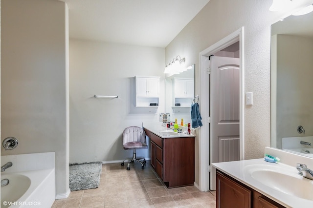 bathroom with tile patterned floors, baseboards, vanity, and a bath