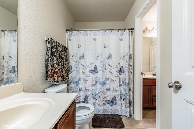 bathroom featuring vanity, tile patterned flooring, toilet, and curtained shower