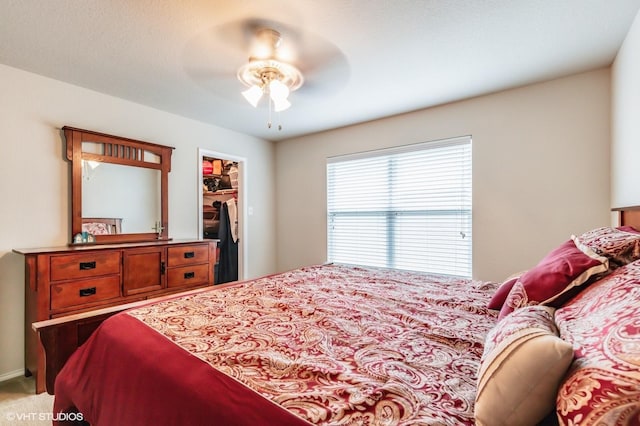 bedroom featuring a closet, ceiling fan, and a spacious closet
