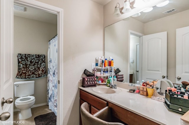 bathroom with vanity, toilet, and visible vents