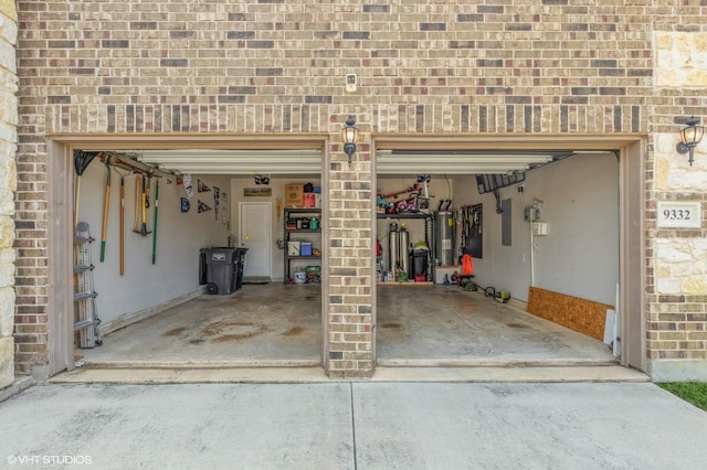 garage featuring driveway and water heater