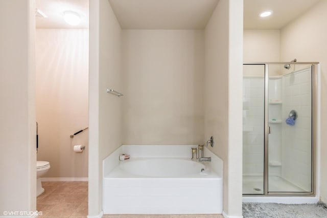 bathroom featuring toilet, tile patterned floors, baseboards, a shower stall, and a bath