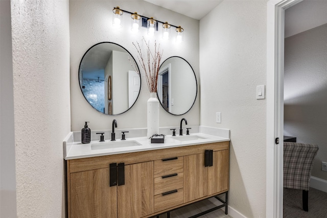 full bath with double vanity, a sink, and a textured wall
