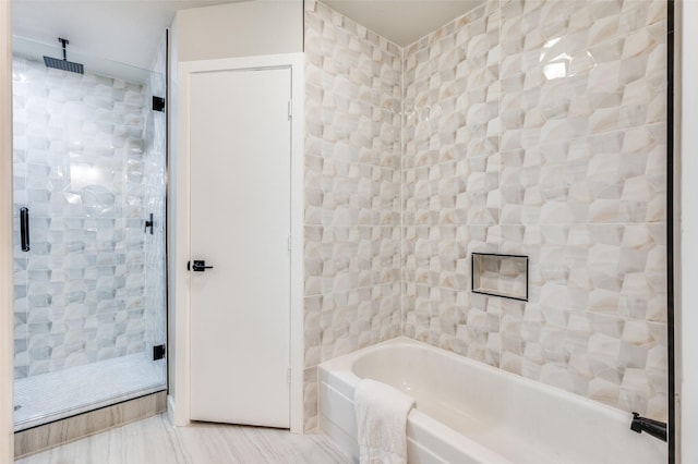 full bathroom with a tub, tile walls, and a stall shower