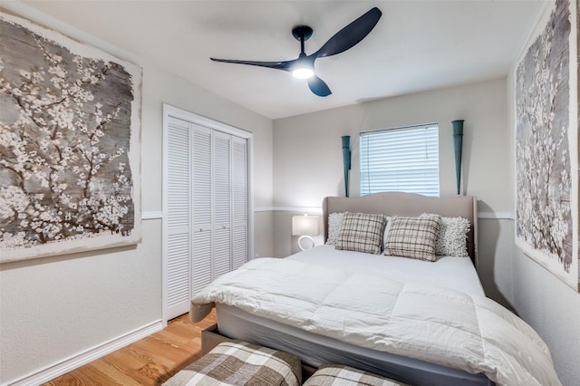 bedroom with baseboards, a ceiling fan, a closet, and wood finished floors