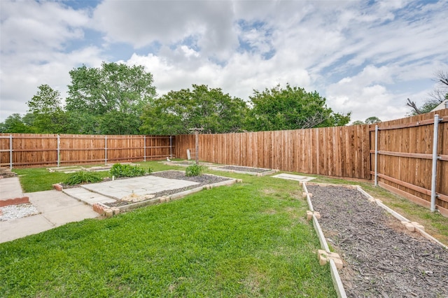 view of yard featuring a fenced backyard, a patio, and a vegetable garden