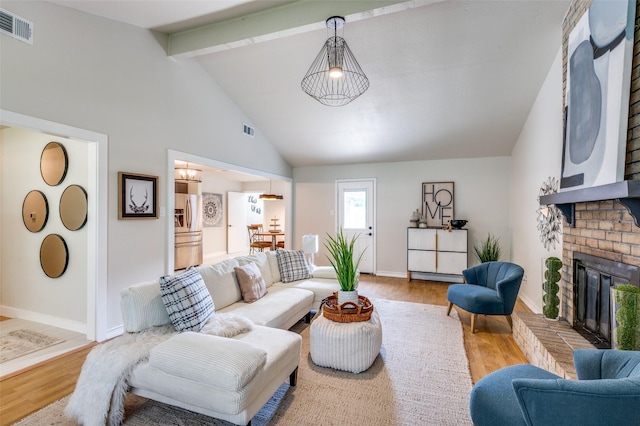 living area featuring wood finished floors, beam ceiling, and visible vents