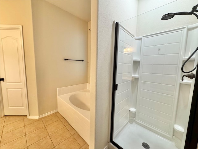 full bathroom featuring tile patterned floors, a shower stall, baseboards, and a garden tub