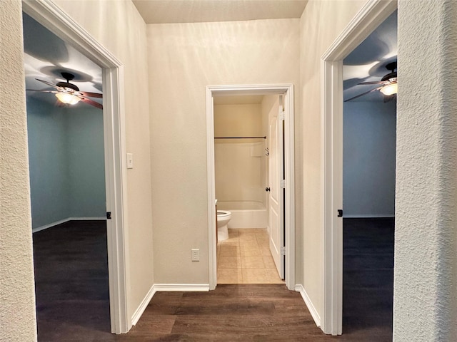 hall with dark wood-type flooring and baseboards