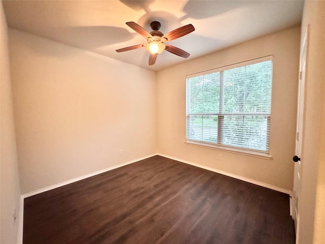unfurnished room with baseboards, dark wood-style flooring, and ceiling fan