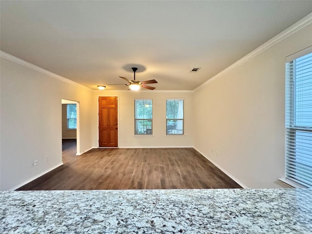unfurnished living room featuring visible vents, plenty of natural light, crown molding, and wood finished floors