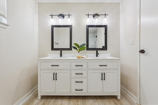 full bath featuring a sink, baseboards, and wood finished floors
