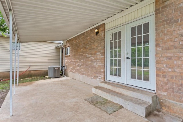 view of patio / terrace with french doors, an attached carport, entry steps, and central AC