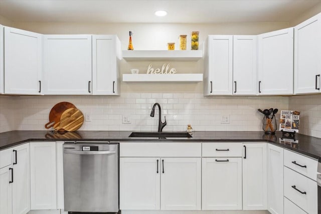 kitchen featuring stainless steel dishwasher, open shelves, dark countertops, white cabinets, and a sink
