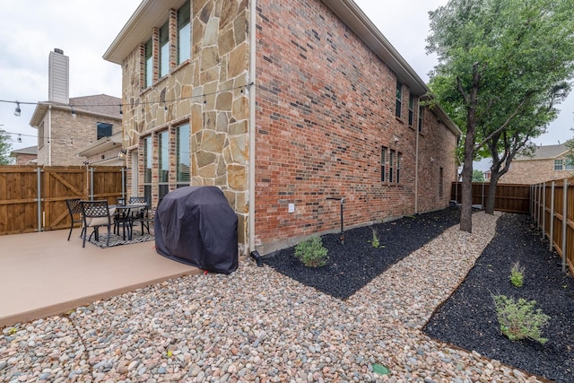 12472 Jack Pine Ct, Frisco, TX 75035 - view of side of home featuring a patio, a fenced backyard, and brick siding