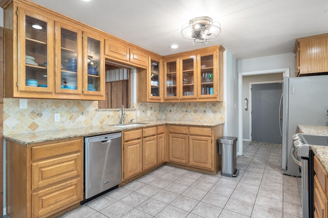 231 Granada Calle St, Granbury, TX 76049 - kitchen featuring appliances with stainless steel finishes, a sink, tasteful backsplash, light stone countertops, and recessed lighting