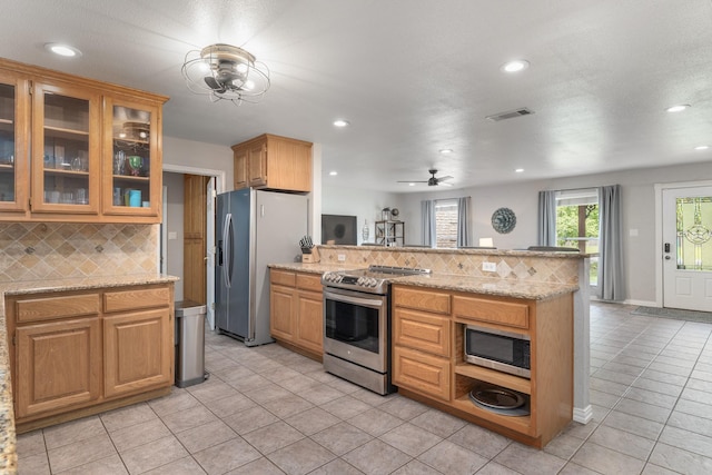 231 Granada Calle St, Granbury, TX 76049 - kitchen with stainless steel appliances, a peninsula, tasteful backsplash, recessed lighting, and light tile patterned floors