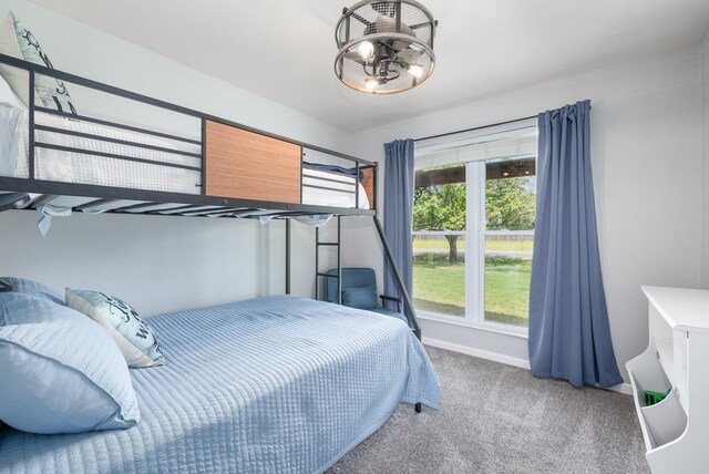 231 Granada Calle St, Granbury, TX 76049 - bedroom featuring multiple windows, carpet, a chandelier, and baseboards