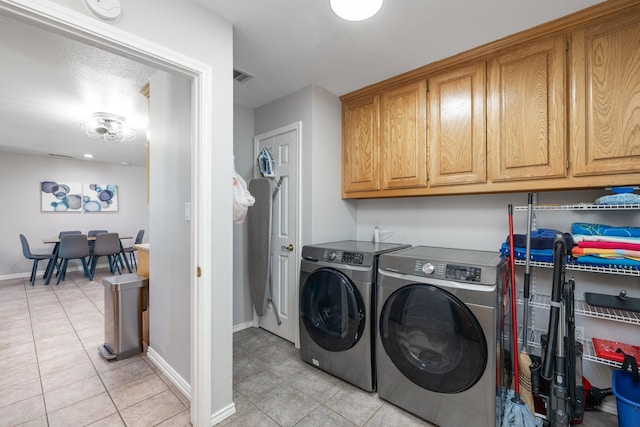 231 Granada Calle St, Granbury, TX 76049 - laundry area featuring cabinet space, washer and clothes dryer, light tile patterned floors, and baseboards