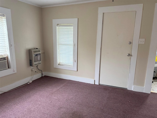 carpeted spare room featuring ornamental molding, heating unit, and a healthy amount of sunlight