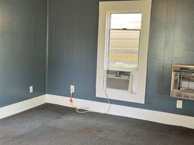 unfurnished room featuring heating unit, a wealth of natural light, carpet, and cooling unit
