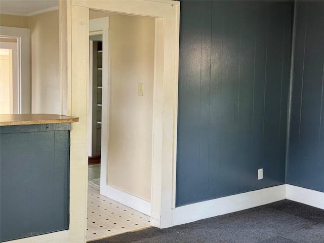 carpeted spare room featuring crown molding