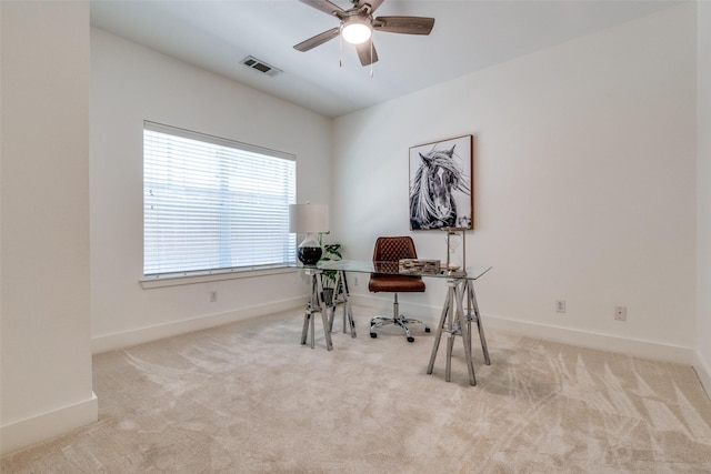 office space with visible vents, carpet flooring, baseboards, and ceiling fan